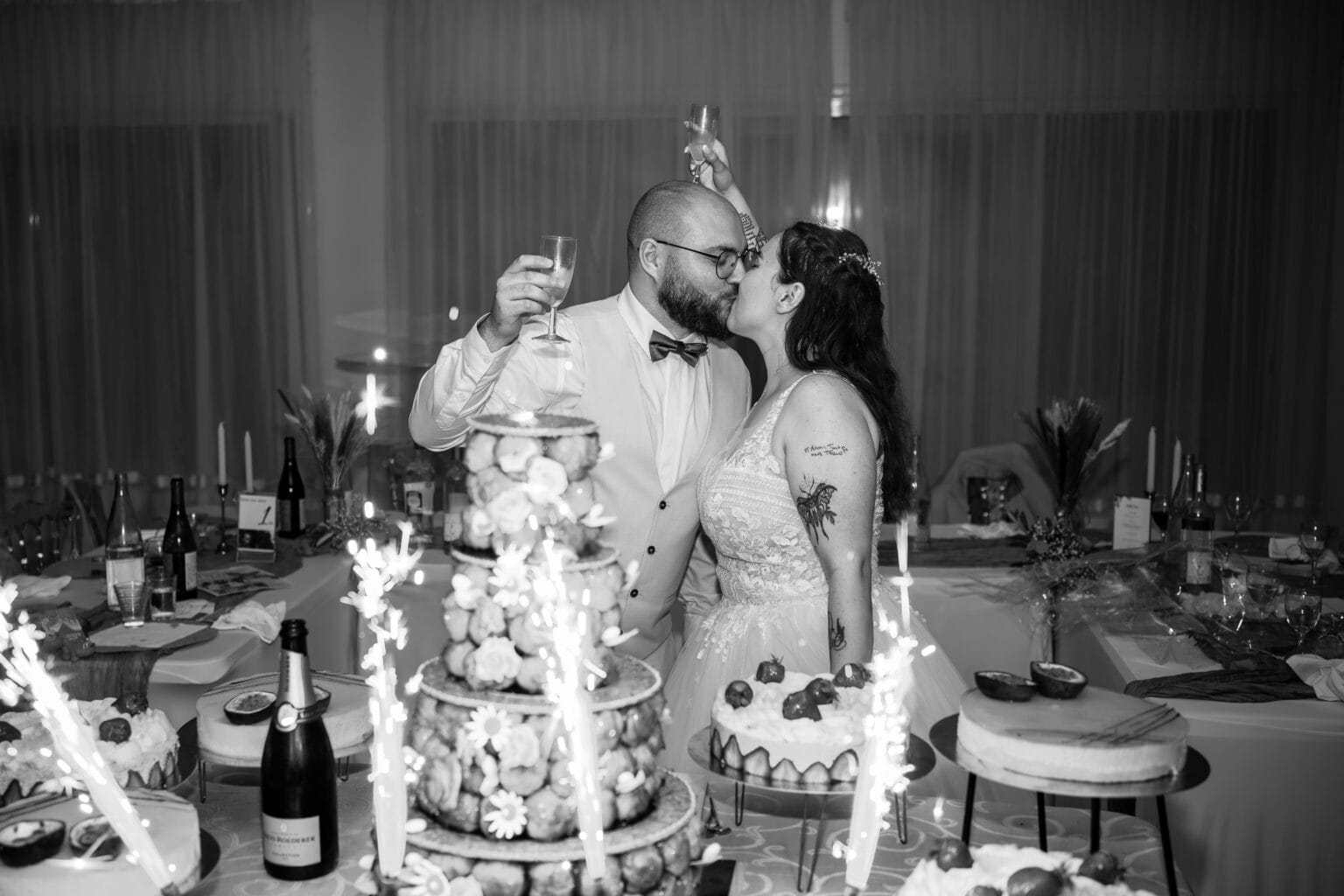 bisou des mariés devant le gâteau de mariage